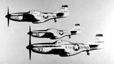 Three P-51s in flight with tight formattion